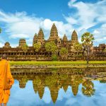 Two Buddhists looking at the Angkor Wat temple across a lake